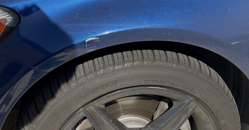Wheel and front wing before cleaning — brake dust on the spokes and flat, dusty paint